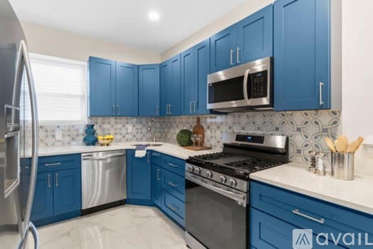 A kitchen with blue cabinets and a black stove top.
