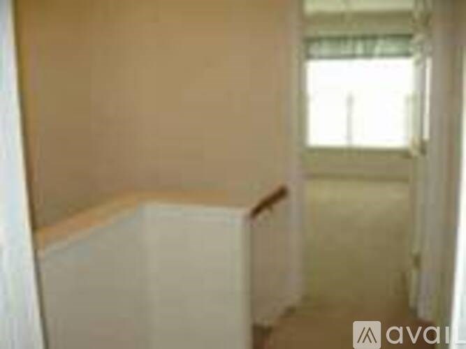 A room with a window and a white wall.