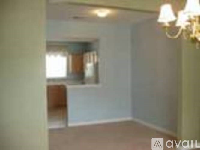 A room with a chandelier and a window.