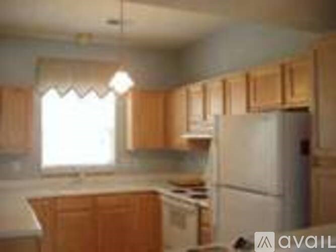 A kitchen with wooden cabinets and a white refrigerator.