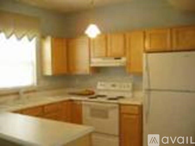 A kitchen with wooden cabinets and a white stove top oven.