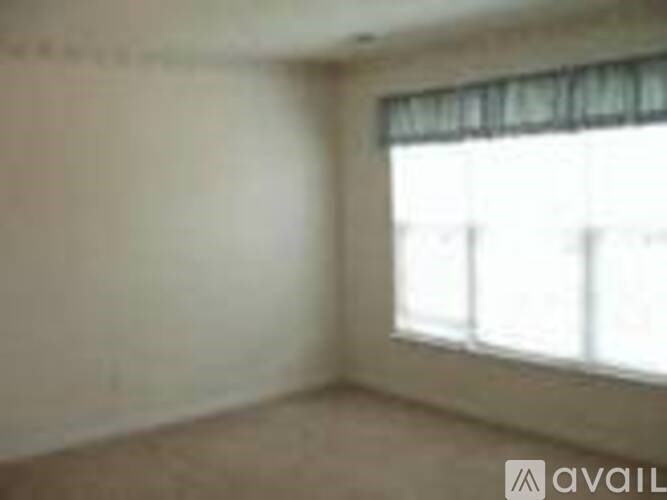 A room with a window covered by a white blind.