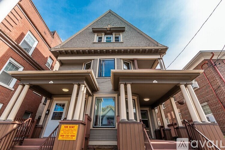 A house with a "For Rent" sign in front of it.