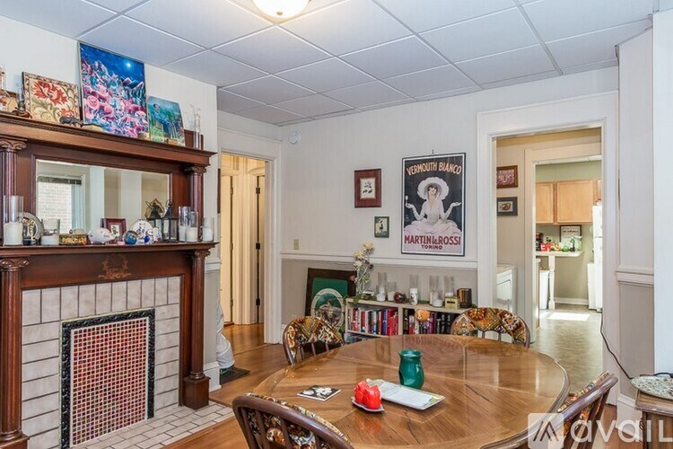 A living room with a fireplace and a dining table.
