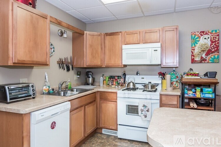 A kitchen with wooden cabinets and a white dishwasher.