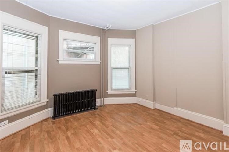 A room with a radiator and two windows.