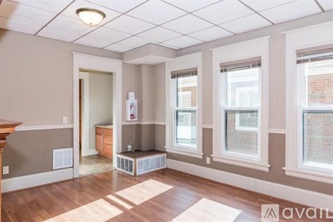 A room with a window, a door, and a wall-mounted air conditioner unit.