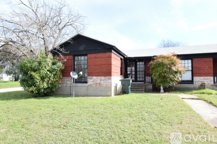 A red brick building with a black roof and a white sign on the front.