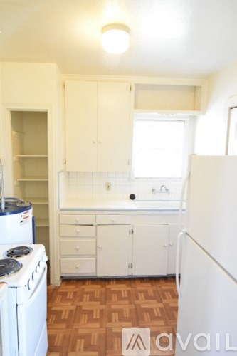 A small kitchen with white appliances and cabinets.