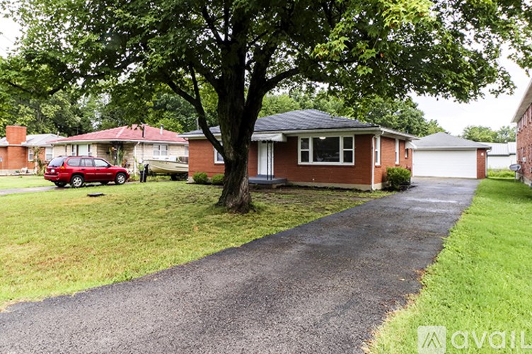 A red car is parked in front of a house.