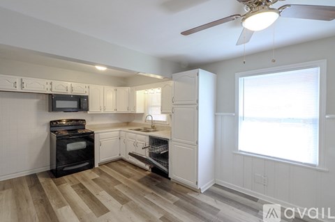 A kitchen with white cabinets and a black stove top oven.