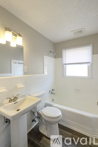 A white bathroom with a sink, toilet, and bathtub.
