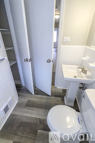 A bathroom with a toilet, sink, and a walk-in shower.