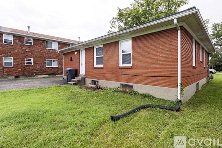 A red brick house with a white door and windows.