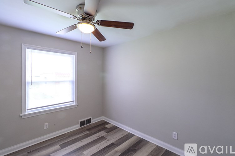 A room with a ceiling fan and a window.