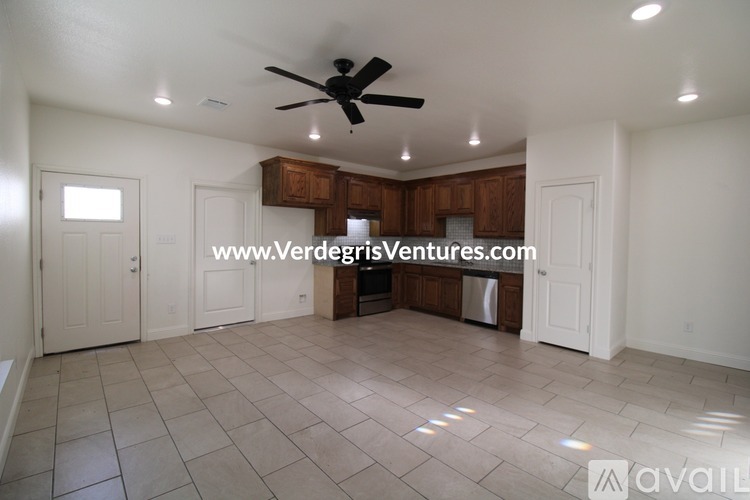 A spacious room with a ceiling fan and tiled flooring.