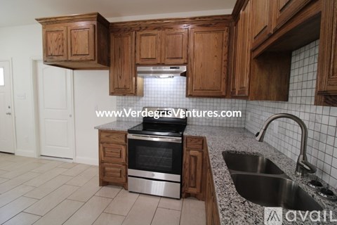 A kitchen with wooden cabinets and a stainless steel oven.