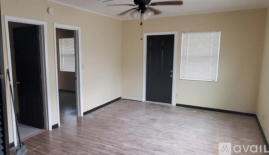A room with a ceiling fan and a window with blinds.