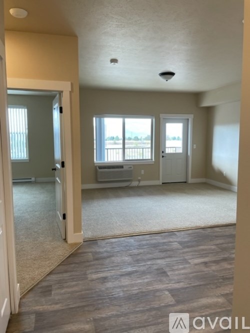 A room with a carpeted floor and a window overlooking a deck.