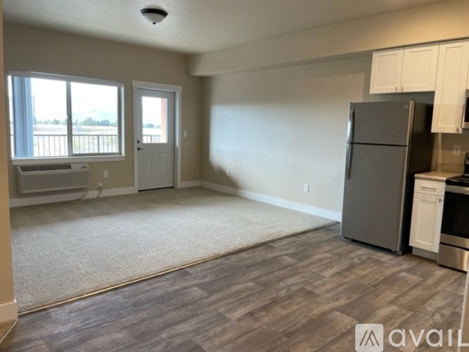 A kitchen area with a refrigerator, oven, and cabinets.