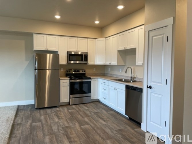 A kitchen with white cabinets and a stainless steel refrigerator.