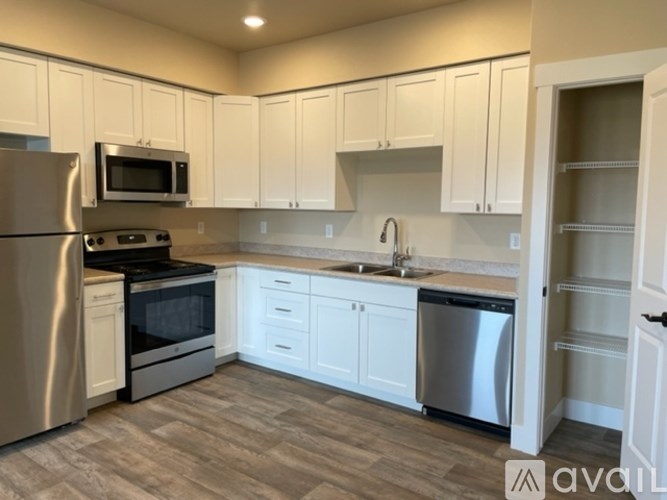 A kitchen with white cabinets and a stainless steel refrigerator.