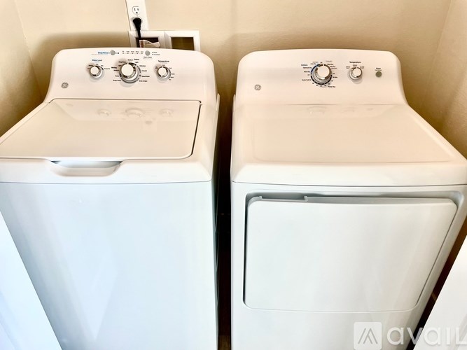 Two white washing machines in a small room.