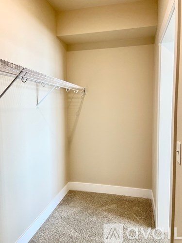 A small, empty room with a carpeted floor and a white door.