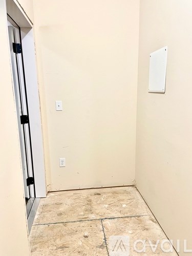 A room with a door and a wall socket.