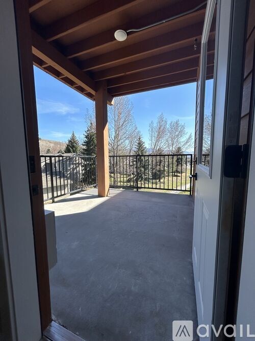 A patio with a black fence and a wooden roof.