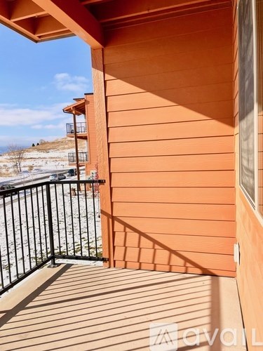 A balcony with a black railing and a view of a snowy landscape.