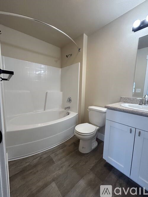 A bathroom with a white tub, toilet, and sink.