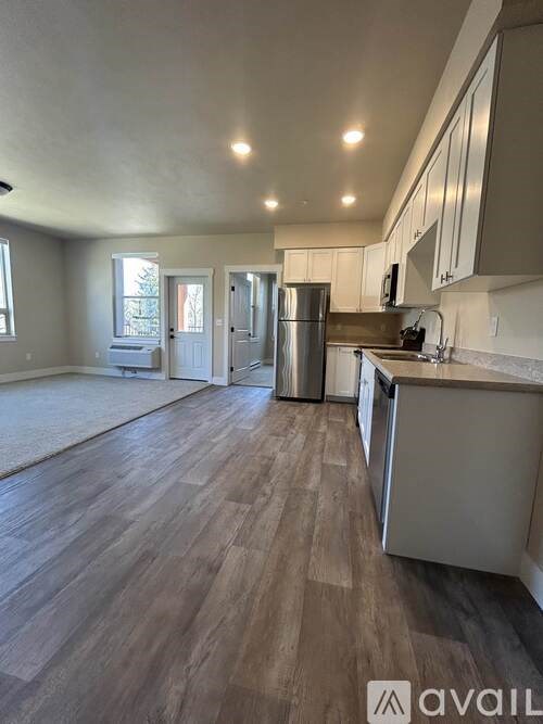 A kitchen with wooden floors and stainless steel appliances.