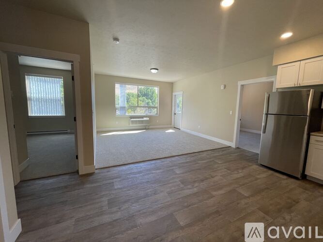 A spacious kitchen with a refrigerator and a dining area with a table and chairs.