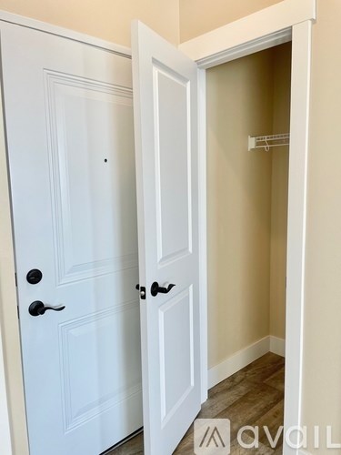 A white door with a black handle is open.