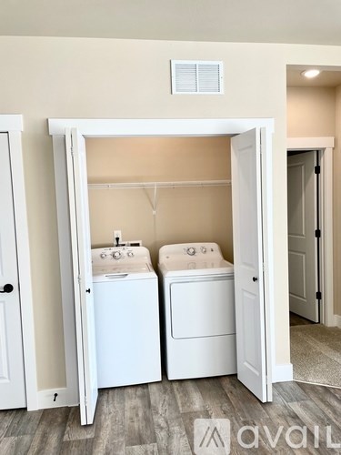 A laundry room with two washing machines and a white door.
