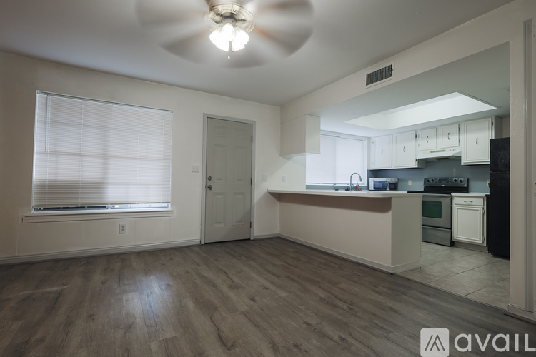 A kitchen with white cabinets and a black countertop.