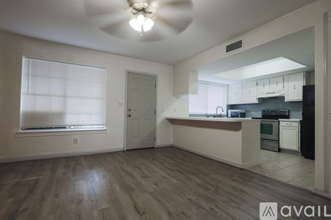 A kitchen with white cabinets and a black countertop.