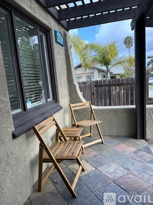Three wooden chairs are placed on a patio.