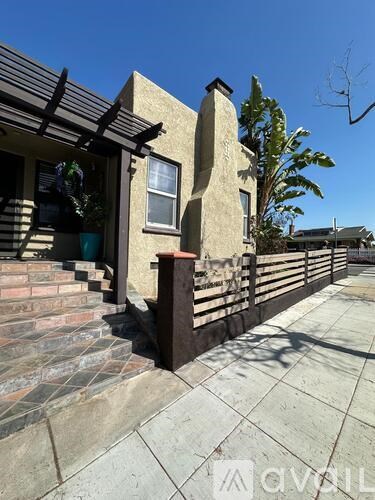 A house with a brown roof and a white fence.
