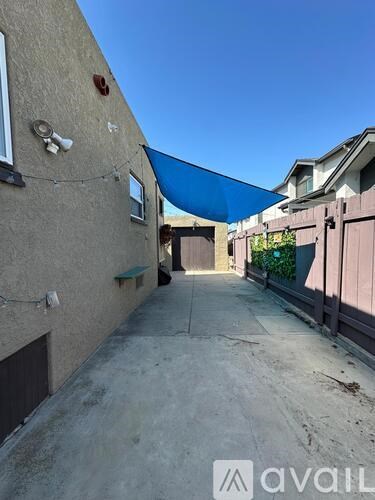 A narrow alley with a blue tarp covering the top.