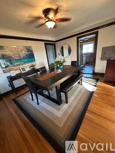 A room with a wooden floor and a long table with chairs.