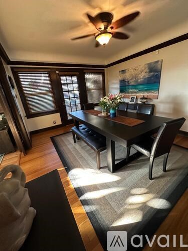 A dining room with a wooden table and chairs.