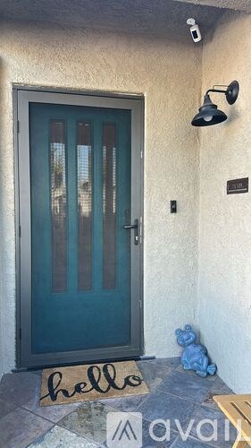 A blue door with a glass panel and a sign on the floor that says "hello".