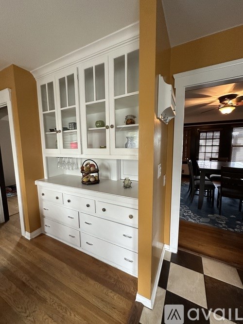 A kitchen with white cabinets and drawers with a basket on top.