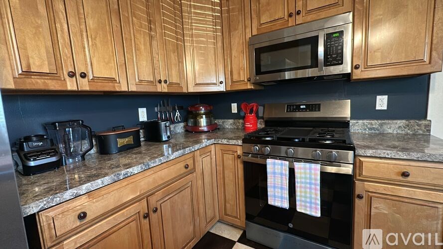 A kitchen with wooden cabinets and a black stove top oven.
