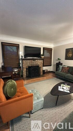 A living room with a fireplace and a television.