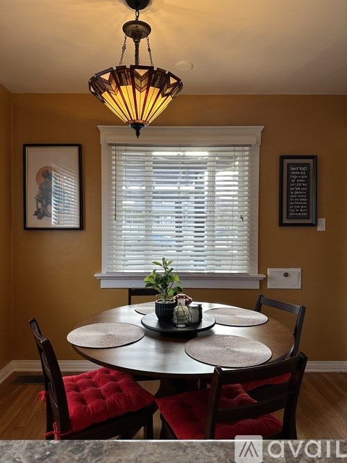 A dining room with a round table and chairs.