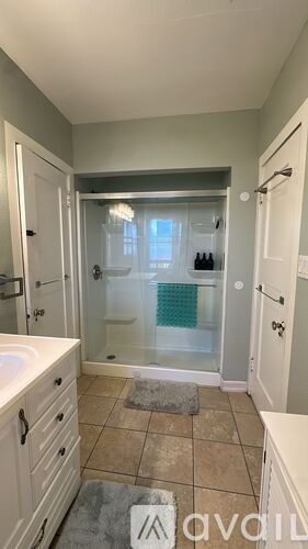 A bathroom with a glass shower door and a white sink.