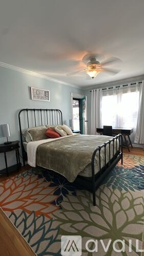 A bedroom with a bed, nightstand, and window.